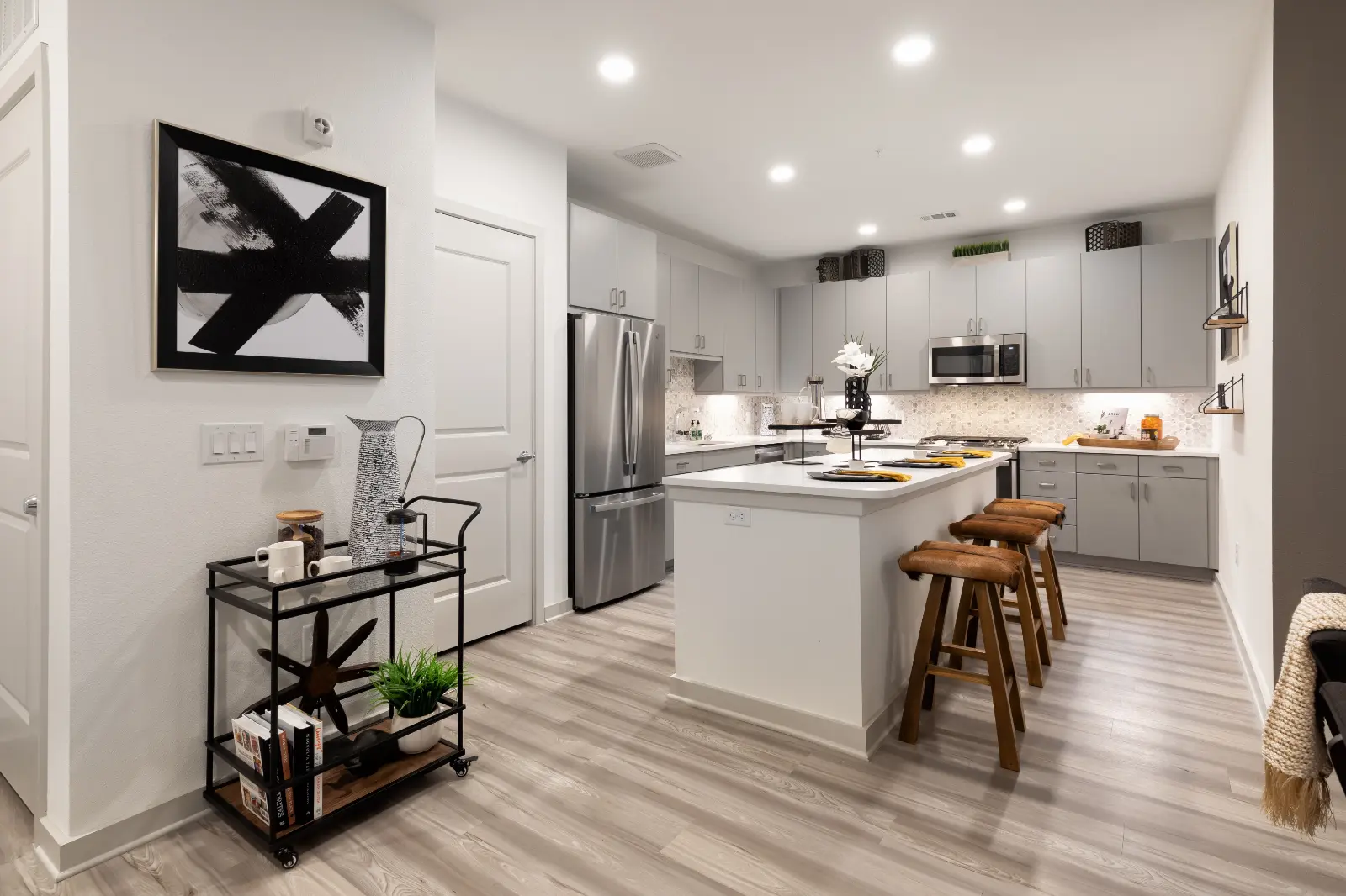 Model kitchen at Alta River Oaks Apartments in Houston, Texas, featuring wood grain flooring and counter seating